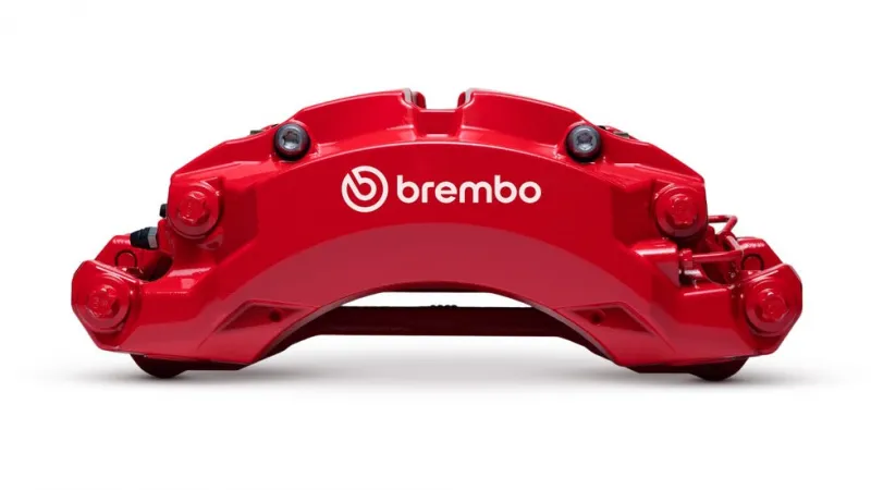 Красный тормозной калипер Brembo на черном фоне, демонстрирующий дизайн и брендирование