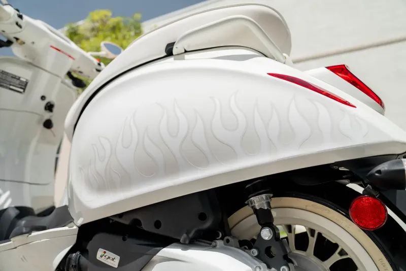 Дизайнерский скутер Vespa с огненной графикой и белыми колесами