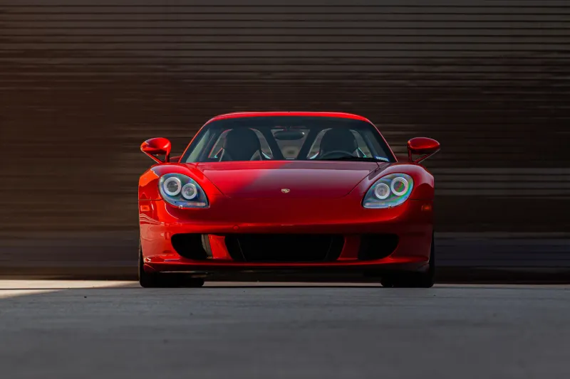 Вид сбоку на перекрашенный в ярко-красный оттенок Porsche Carrera GT